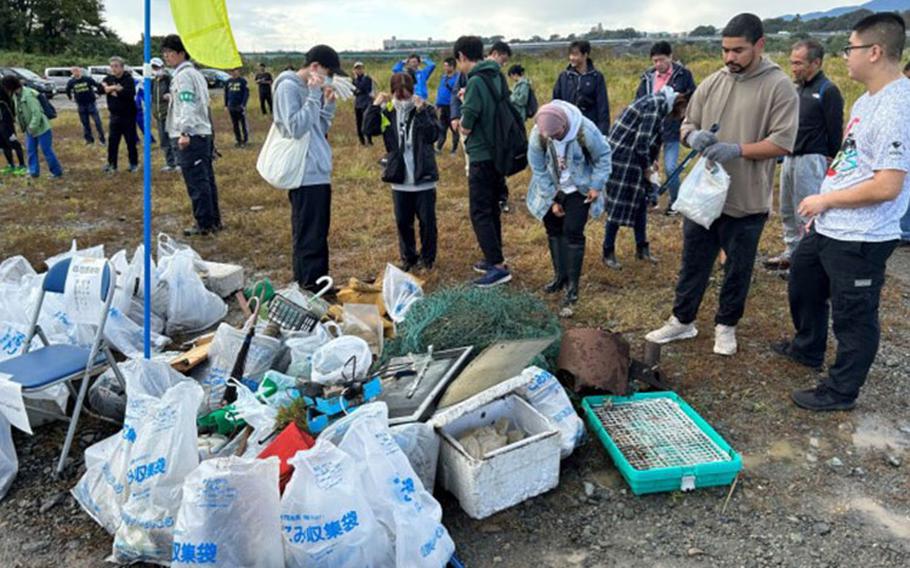 Volunteers drop off bags of garbage they helped clean during a volunteer event Oct. 29 at the Sagamihara City Shindo Sports Park near Camp Zama. More than 100 volunteers worked together for the community cleanup.