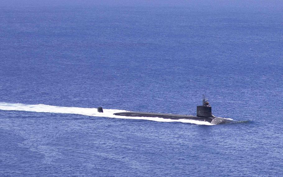 A submarine surfaces, leaving a wake.