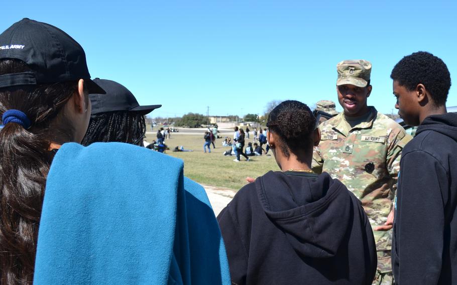 Soldier speaks with high school students.