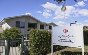 A housing complex behind a gate and a sign that says “Embassy of the Islamic Republic of Iran.”