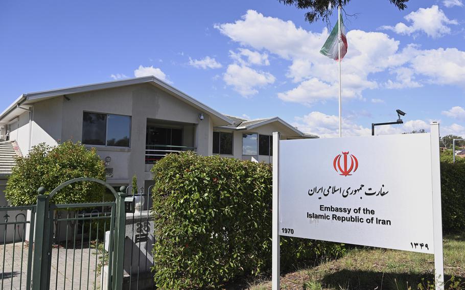 A housing complex behind a gate and a sign that says “Embassy of the Islamic Republic of Iran.”