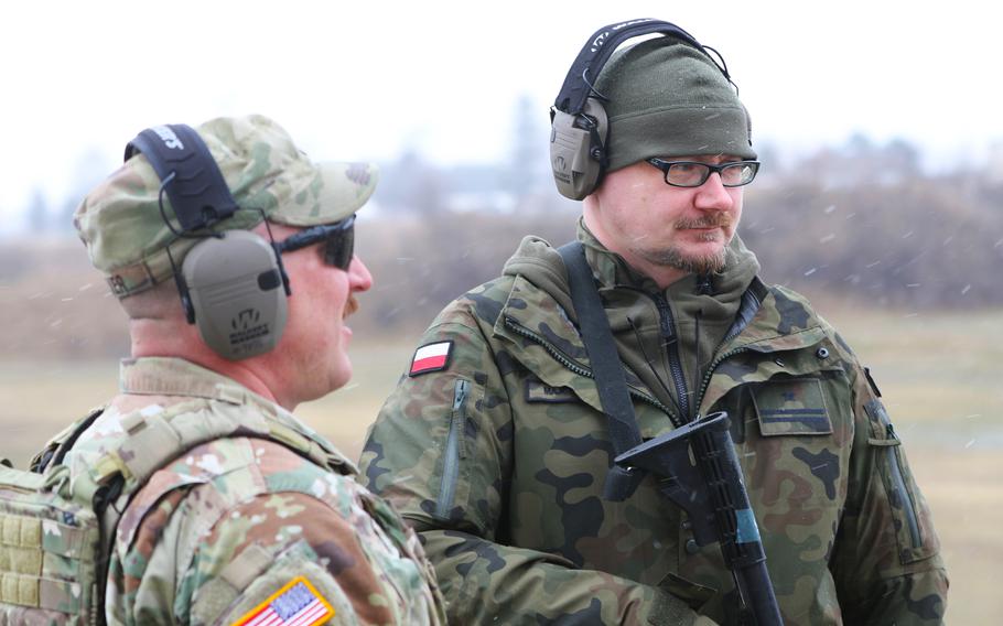 Capt. Drew Weaver of the Illinois Army National Guard discusses firing weapons with Maj. Andrew Majcherek of the Polish Territorial Defense Force on a range at the Guard’s Marseilles Training Area on March 25, 2023. 