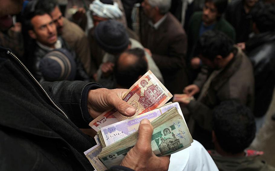 Men buy and trade currencies at a money market in Kabul, Afghanistan, in 2010. The country’s currency, the afghani, isn’t accepted for cross-border trade, thus the economy’s reliance on U.S. dollars and the hawala industry. 