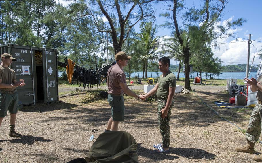 U.S. Navy Lt. Cmdr. Michael Dobling, left, commander of Underwater Construction Team 2, gives a coin to a Philippine navy sailor at Naval Base Camilo Osias, Santa Ana, Cagayan, Philippines, May 11, 2018.