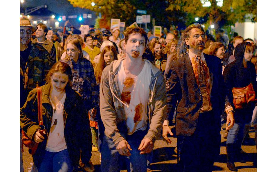 People who are not actually undead lumber down a street in Silver Spring, Md., for the 2013 Zombie Walk. 