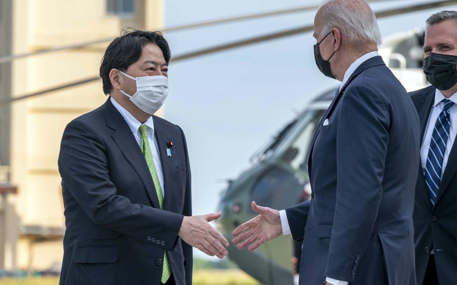 Japanese Minister for Foreign Affairs Hayashi Yoshimasa greets President Joe Biden at Yokota Air Base in western Tokyo, May 22, 2022.