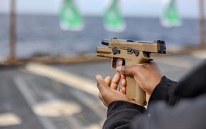 PHILIPPINE SEA (February 22, 2025) – Retail Specialist Seaman Cyrenity Carter from Gulf Port, Mississippi, reloads an M18 SIG during a small arms gun shoot on the flight deck of the Arleigh Burke-class guided-missile destroyer USS Ralph Johnson (DDG 114) while underway in the Philippine Sea, Feb. 22. Ralph Johnson is forward deployed and assigned to Destroyer Squadron (DESRON) 15, the Navy’s largest DESRON and the U.S. 7th fleet’s principal surface force. (U.S. Navy photo by Mass Communication Specialist 1st Class Hannah Fry)