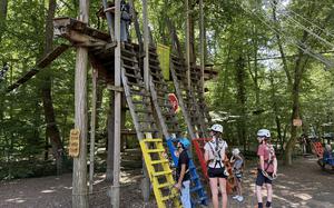 Climbers prepare to embark on a course at the Fun Forest adventure park in Kandel on July 5, 2025. The adventure park offers 16 climbing routes of varying difficulty, featuring bridges, ziplines and rope swings. 
