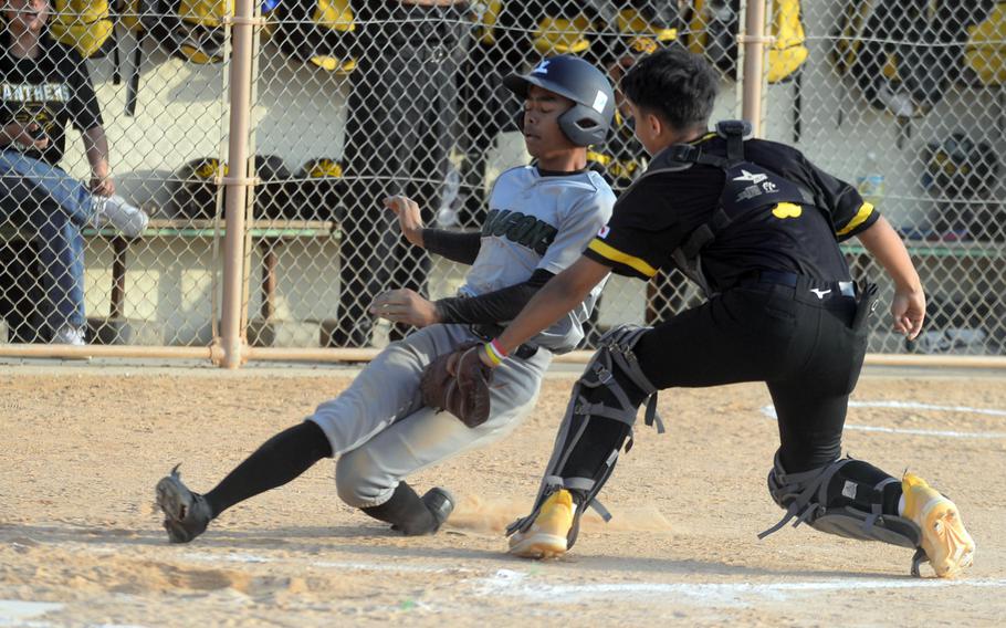 Kubasaki's Luka Koja gets tagged out short of home plate by Kadena catcher Waioni Mandac during Monday's DODEA-Okinawa baseball game. The Dragons won 16-0.