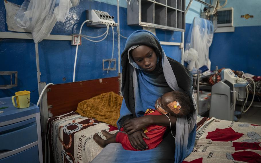 Mawada Mohamed, 17, cradles her 1-year-old sister, Aza Ismail, who is hospitalized in the MSF/Doctors Without Borders-run “inpatient therapeutic feeding center” at the hospital in El Geneina, the only referral hospital in all of West Darfur, Sudan.