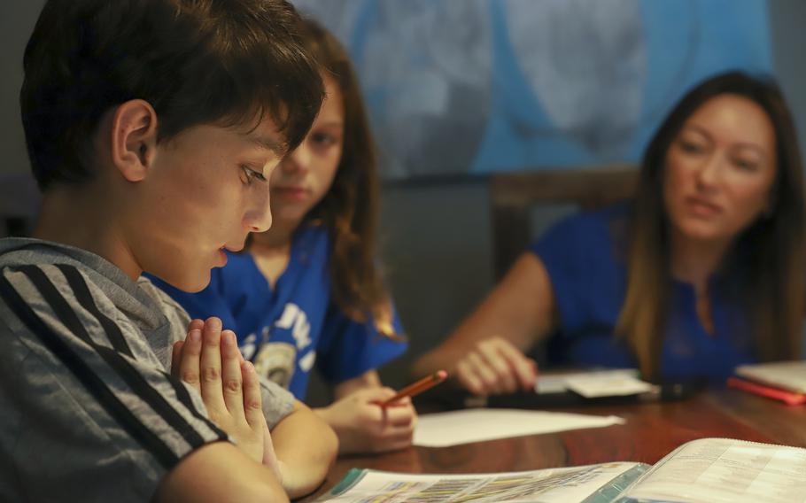 Roberta Satill helps children Jaydon and Talia with their homework in Longwood, Fla.