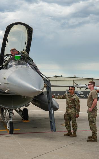 A man climbing into a plane with two others standing to the side