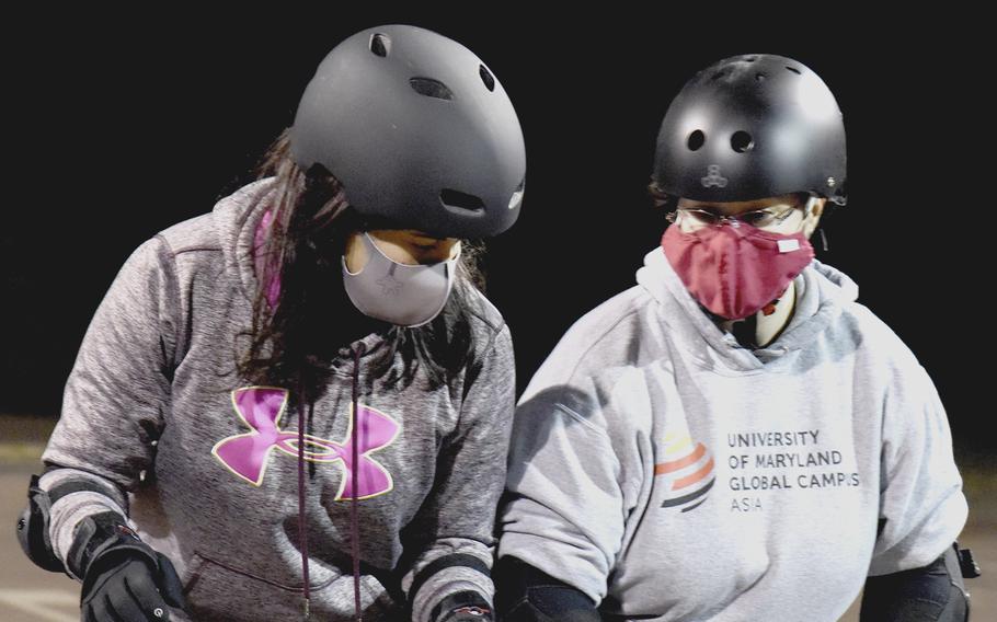 Coach Hannah Howard, right, teaches Mimi Torres how to block with her hips during a roller derby practice at Yokota Air Base, Japan, on Feb. 28, 2022.