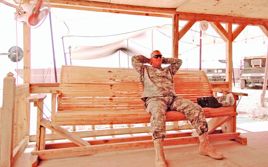 Sgt. 1st Class Mark Greenwell, 48, Century, Fla., with the 842nd Signal Battalion, sits on a swing during a break this week at FOB Sykes. The swing and camp were all built from scratch, with the working on it for a little over six months.