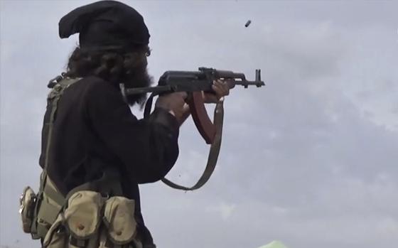 FILE - This file frame grab from video posted online March 18, 2019, by the Aamaq News Agency, a media arm of the Islamic State group, shows an IS fighter firing his weapon during clashes with the U.S.-backed Syrian Democratic Forces (SDF) fighters, in Baghouz, Syria. Gunmen ambushed a bus carrying Syrian soldiers early Friday, Aug. 11, 2023 in the country’s east, killing at least 20 and wounding others, opposition activists said. The attack was believed to be carried out by members of the Islamic State group whose sleeper cells in parts of Syria still carry deadly attacks despite their defeat in 2019. (Aamaq News Agency via AP, File)