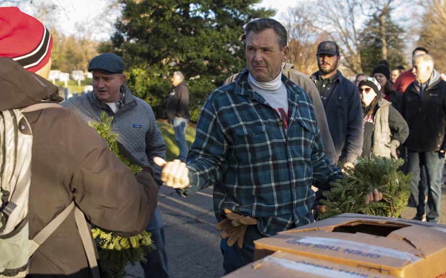 Marine veteran Joe McNamara beckons for another wreath at Arlington National Cemetery on Saturday, Dec. 17, 2022.