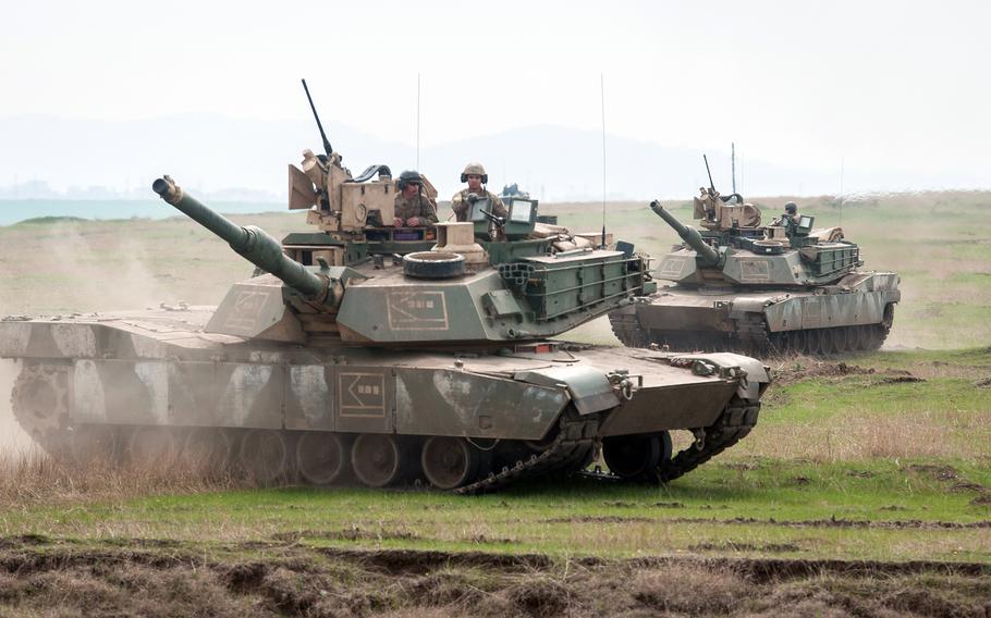 U.S. soldiers maneuver M1A2 Abrams tanks during an exercise with Romanian allies in 2018 at Smardan Training Area, Romania. A Romanian army general said in an interview published March 7, 2023, that his country intends to buy enough U.S.-made Abrams tanks for a battalion.