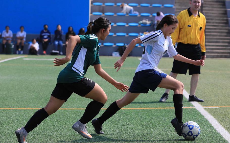 Osan’s Vivian Machmer dribbles ahead of Daegu’s Leah Williamson during Tuesday’s DODEA-Korea soccer match. The Warriors won 4-3.