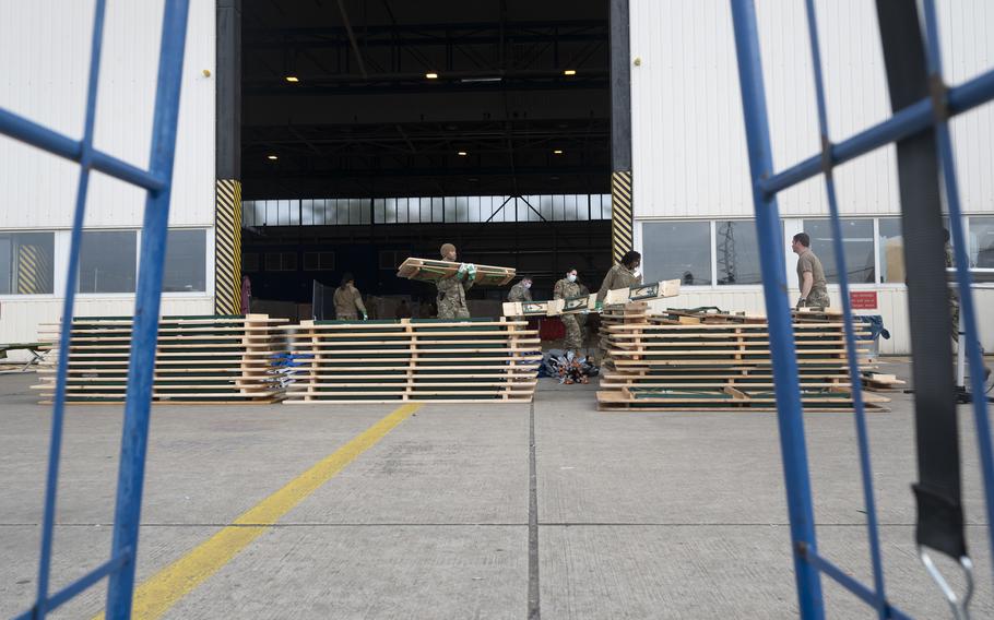 Airmen move benches and tables while dismantling temporary living facilities for Afghan evacuees at Ramstein Air Base, Germany, on Oct. 14, 2021. Equipment used to house and care for evacuees for nearly two months is being removed as the operation to support tens of thousands who fled Afghanistan winds down. As of Monday, less than 200 evacuees remained at U.S. bases in and near Kaiserslautern, Germany.