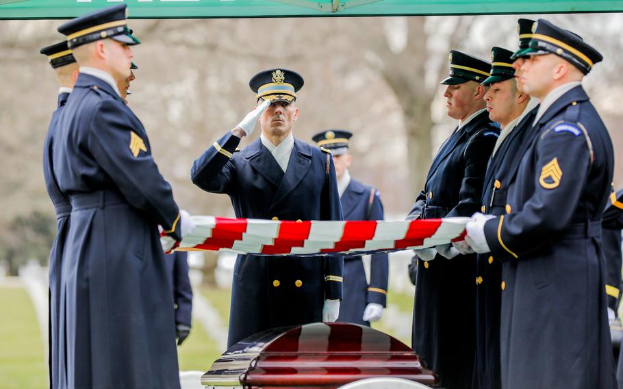 A soldier of the Old Guard salutes as the flag is removed from the coffin of retired Gen. Montgomery C. Meigs at Arlington National Cemetery, Jan. 25, 2022. Meigs, the former commander of U.S. Army Europe, died July 6, 2021.