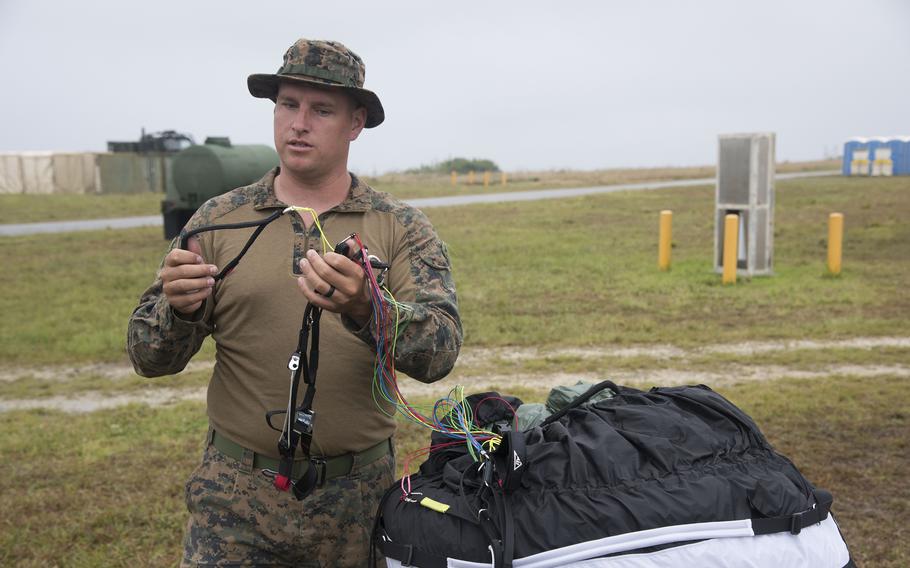 A Marine shows how the glider portion of a powered paraglider works.