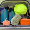 twosuitcases and many bags in the trunk of the car ready to depart