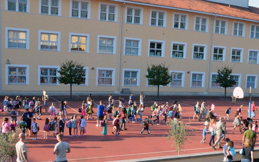 Elementary students play on the playground that separates the school from the Middle/High School (background) at Aviano Air Base, Italy.