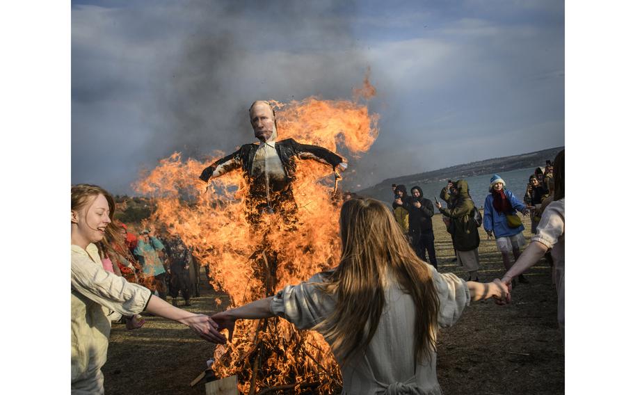 People participate in the burning of the doll of Russian president Vladimir Putin doll as a part of pagan rituals marking end of winter season and beginning of spring in Tbilisi, Georgia, on March 27, 2022. 