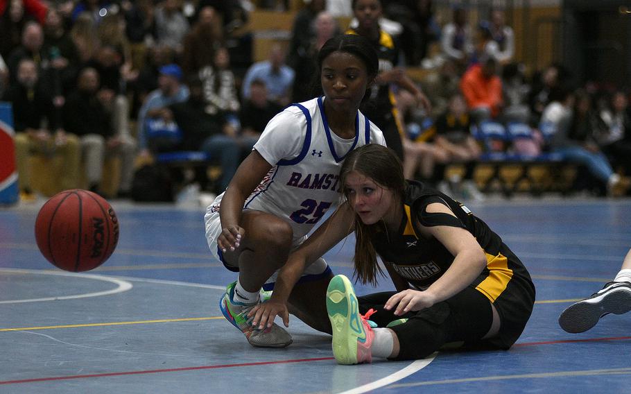 Stuttgart's Madison McQueen and Ramstein's Brayln Jones watch as the ball bounces away during a basketball game on Dec. 8, 2023, at Ramstein High School on Ramstein Air Base, Germany.