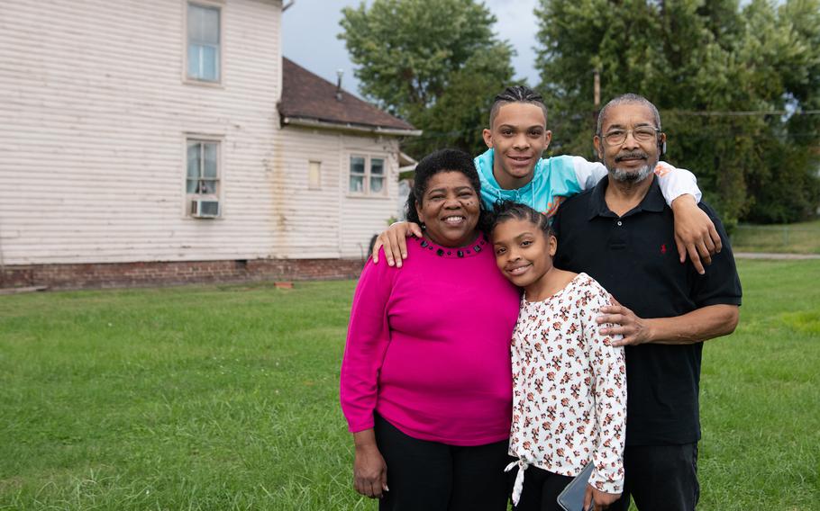 Ruth Jones, left, and her husband, James Jones, pose with their grandchildren Ayricah Clark, 10, and Nilique Jones, 17, near their home in Charleston, W.Va., on Oct. 21, 2021. The Joneses are raising their grandchildren. 