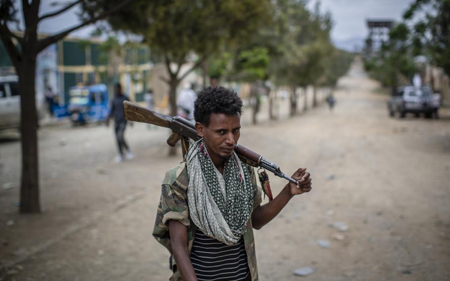 A fighter loyal to the Tigray People's Liberation Front walks along a street in the town of Hawzen, then-controlled by the group, in the Tigray region of northern Ethiopia, on May 7, 2021.