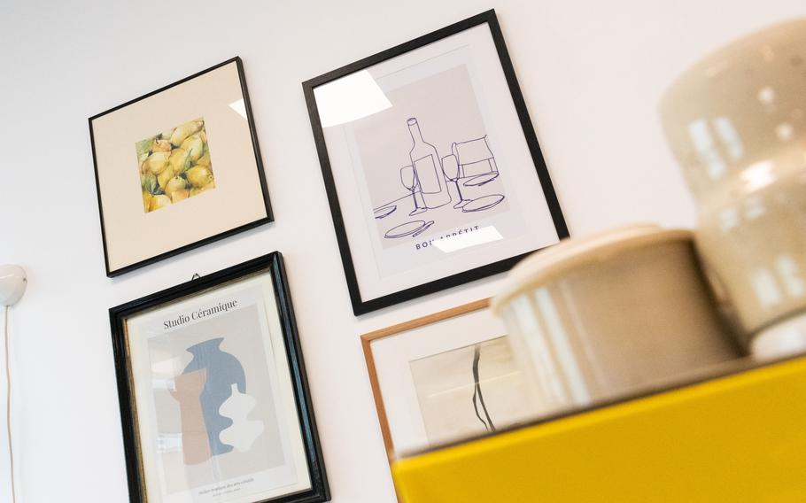 Paintings are displayed on a cafe wall.