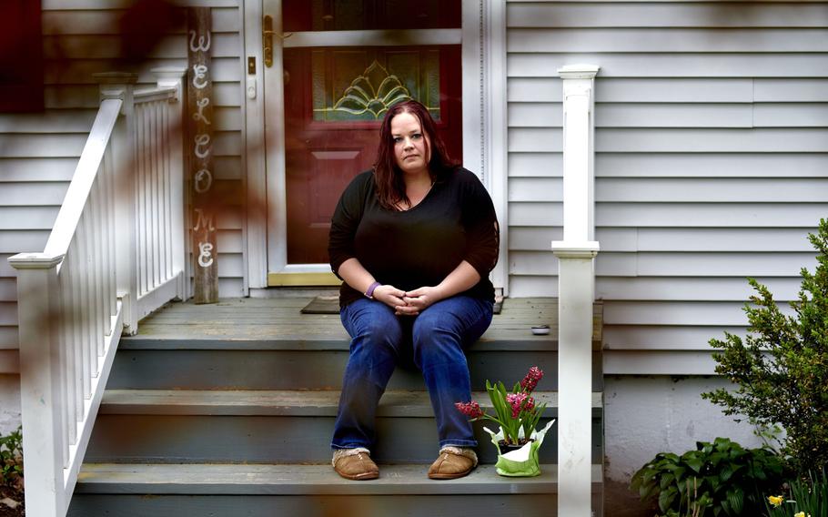 Tasha Clark, who suffers from long-haul COVID, sits on the steps of her home in Milford, Conn., on May 3, 2021.