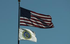 A U.S. flag and the flag of the U.S. Department of Energy fly outside its building on March 18, 2025, in Washington, D.C. (Alex Wong/Getty Images/TNS)