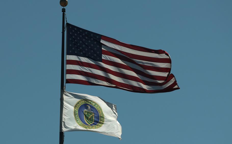 A U.S. flag and the flag of the U.S. Department of Energy (white with a blue and gold logo).