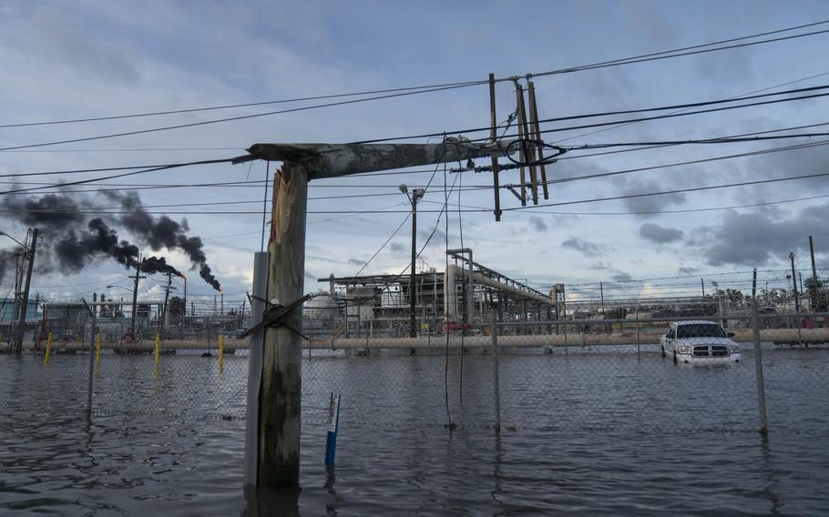 Broken power lines, destroyed by Hurricane Ida, are seen along a highway near a petroleum refinery on August 30, 2021 outside LaPlace, La. 