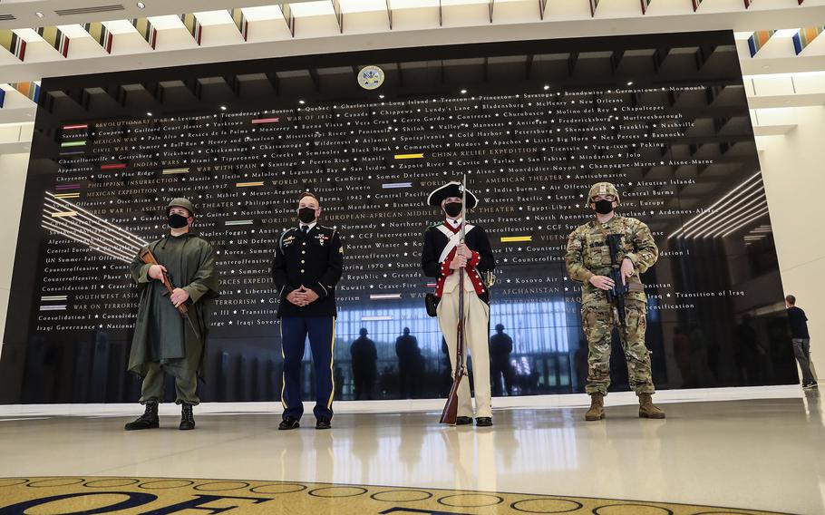 Soldiers from Fort Myer, Va., dressed in uniforms from various eras, stand in front of a display listing the Army's campaigns in the lobby of the National Museum of the United States Army on its reopening day, June 14, 2021, which is also the service's 246th birthday.