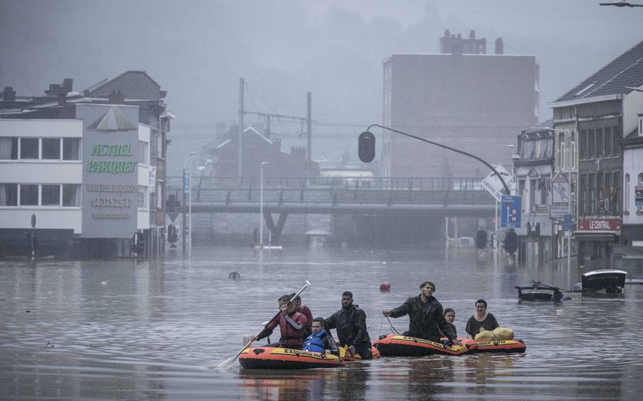 People use rubber rafts in floodwaters after the Meuse River broke its banks during heavy flooding in Liege, Belgium, Thursday, July 15, 2021. 