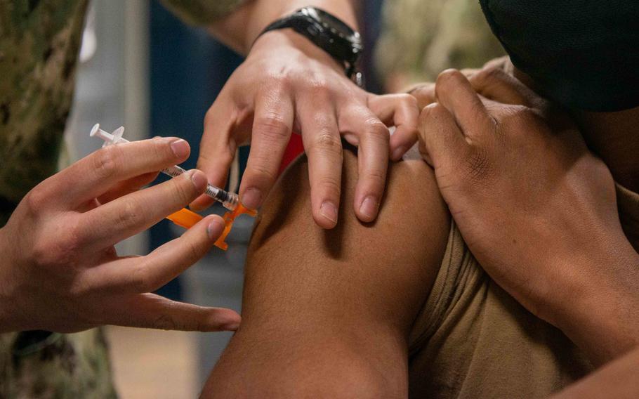 U.S. Navy Boatswain’s Mate Seaman Recruit Daylon Burgess, right, assigned to the aircraft carrier USS John C. Stennis (CVN 74), receives the COVID-19 vaccine from Hospital Corpsman 2nd Class David Bautista, assigned to the aircraft carrier USS George Washington (CVN 73), in the mess decks aboard the ship, in Newport News, Va., May 25, 2021.   