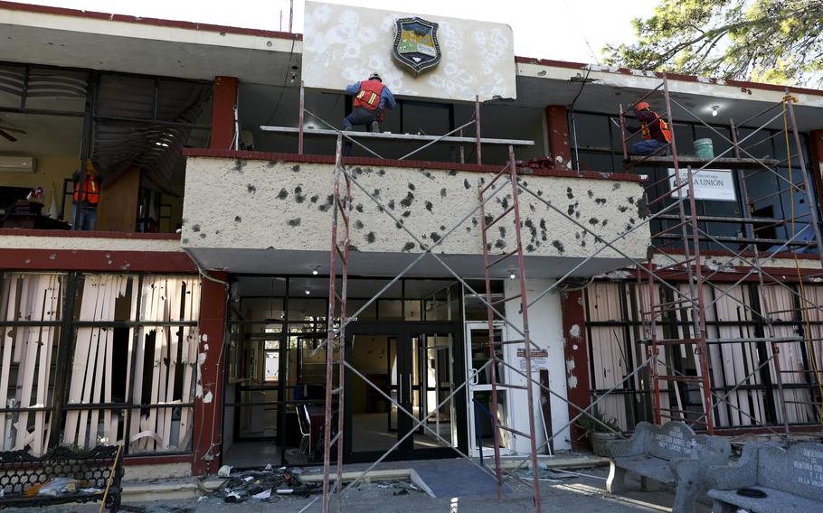 Workers repair the entrance of City Hall riddled in large bullet holes in Villa Union, Mexico, Dec. 2, 2019, after 22 people were killed in a gun battle between a drug cartel and security forces. Mexico wants an urgent investigation into how U.S. military-grade weapons are increasingly being found in the hands of Mexican drug cartels, Mexico’s top diplomat said on Jan. 22, 2024. 