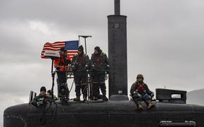 Sailors stand watch from on top of a submarine as it pulls into Reykjavík, Iceland.