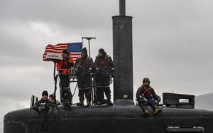 Sailors stand watch from on top of a submarine as it pulls into Reykjavík, Iceland.