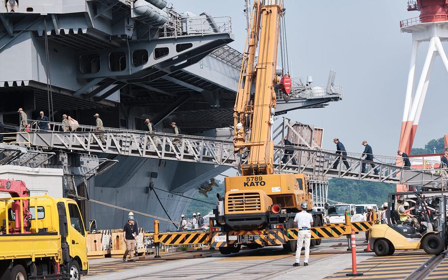 Sailors board the aircraft carrier USS Ronald Reagan at Yokosuka Naval Base, Japan, Friday, May 20, 2022.