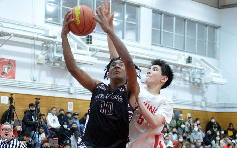 Matthew C. Perry's Shion Fleming shoots against E.J. King's Cameron Reinhart during Friday's DODEA-Japan basketball game. The Cobras won 73-58.