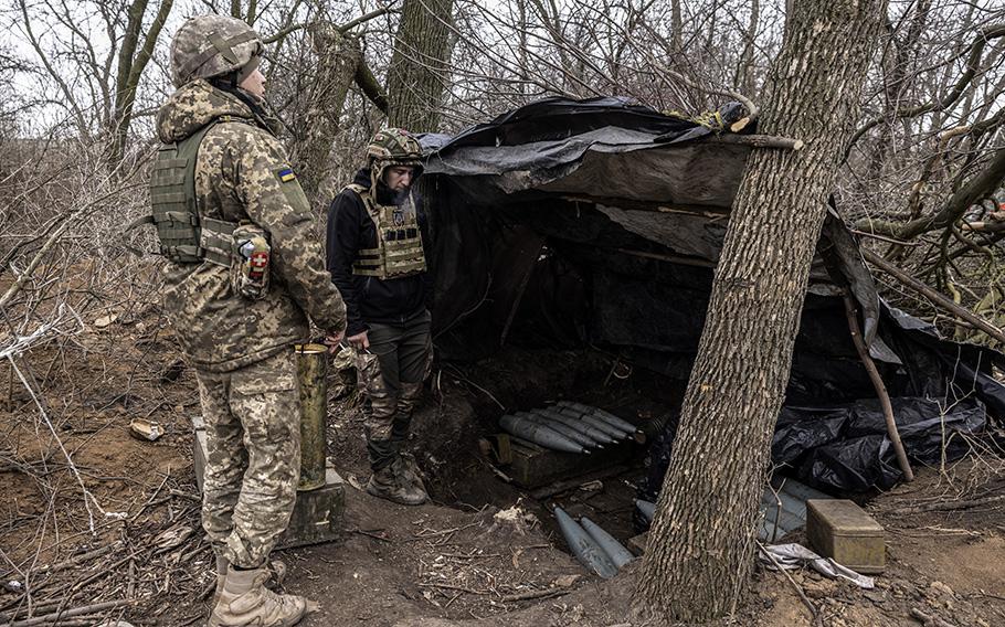 Members of Ukrainian forces stand by artillery shells for a captured Soviet-era Russian 152mm howitzer in the Donetsk region in eastern Ukraine on March 28, 2023.