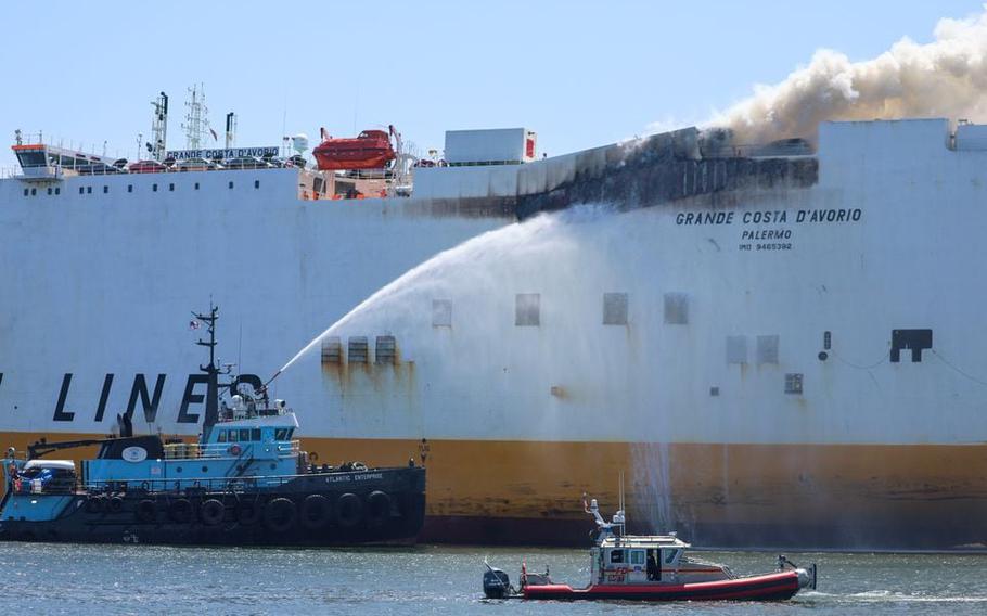 Fire burns aboard the cargo ship Grande Costa d’Avorio where two Newark firefighters were killed battling the fire early this morning. The tugboat Atlantic Enterprise (left) and New York City fireboats pour water on the blaze on July 6, 2023, in Newark, N.J.