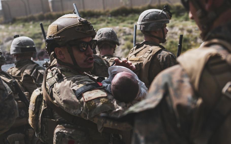 A U.S. service member comforts an infant during an evacuation at Hamid Karzai International Airport, Kabul, Afghanistan, Aug. 20, 2021. 