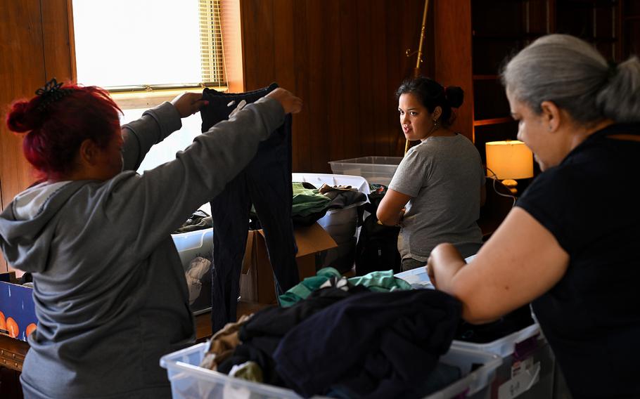 Scarleth Plaza, left, and Diana Lara, center, look through donated clothing at a church across the street from the police station. 
