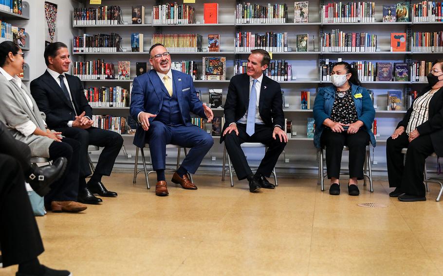 The U.S. Secretary of Education, Miguel Cardona, center in blue suit, joins Los Angeles Mayor Eric Garcetti, to his left and Los Angeles Unified School District (LAUSD) Superintendent Alberto M. Carvalho, to his right, to discuss how LAUSD is leveraging American Rescue Plan funds and other pandemic relief funds, as well as meet with some parents, at Los Angeles High School of the Arts at Robert F. Kennedy Community School in Los Angeles on Wednesday, March 30, 2022. 