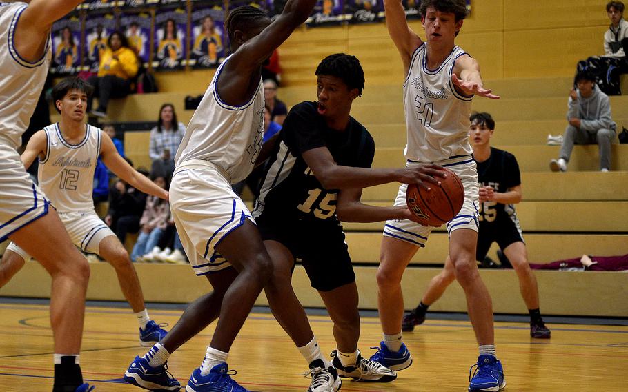 Naples senior Thurman Bruner passes the ball while being defended by Rora's Brian Leiba and Tyler Demerritt during a Division II semifinal at the DODEA European Basketball Championships on Feb. 16, 2024, at Wiesbaden High School in Wiesbaden, Germany.